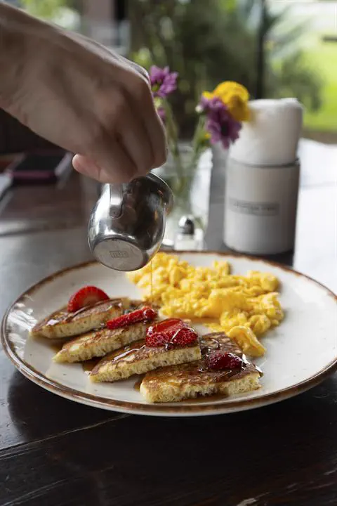 Desayuno servido con flores en la mesa